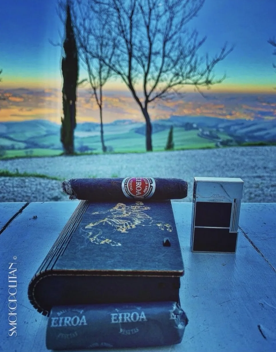 Sigaro davanti a un paesaggio al tramonto
